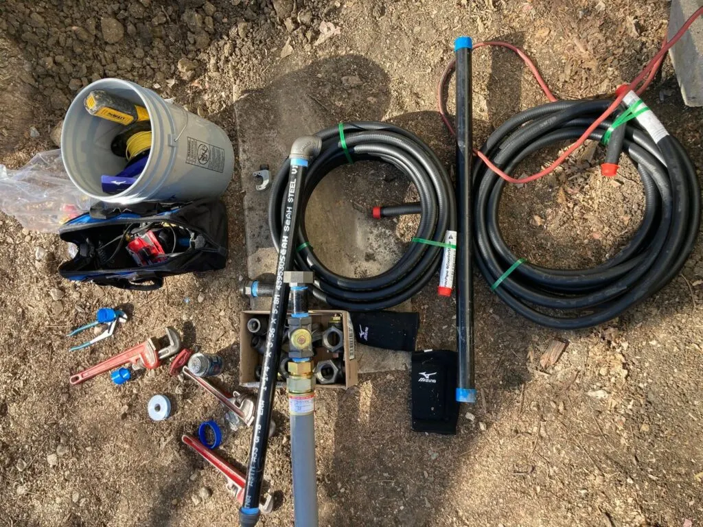 PEX tubing, a manifold and fittings laid out on site before a repipe.