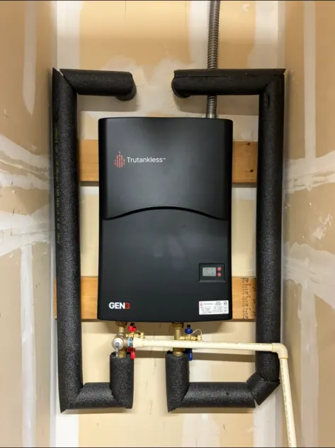 A wall-mounted tankless water heater with insulated hot and cold lines.